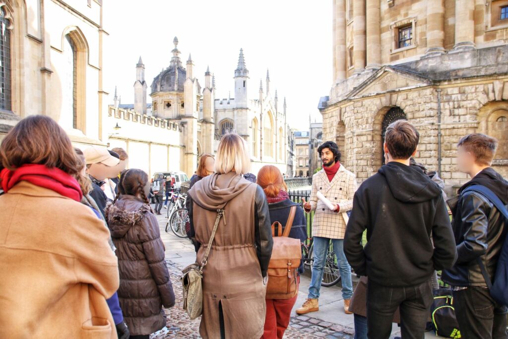 An Uncomfortable Oxford Guide gives a tour to a crowd of people.