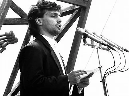 Viktor Orbán stands in front of microphones and gives a speech in 1989.