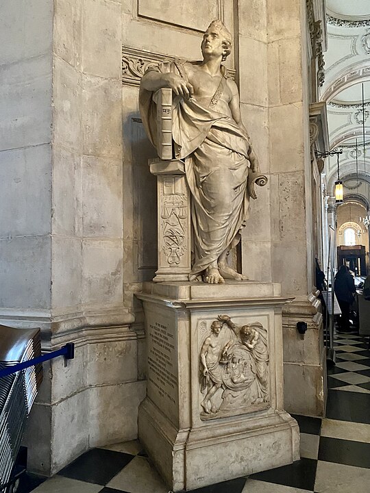 White stone statue of a man in St Paul's Cathedral in roman style robe. 