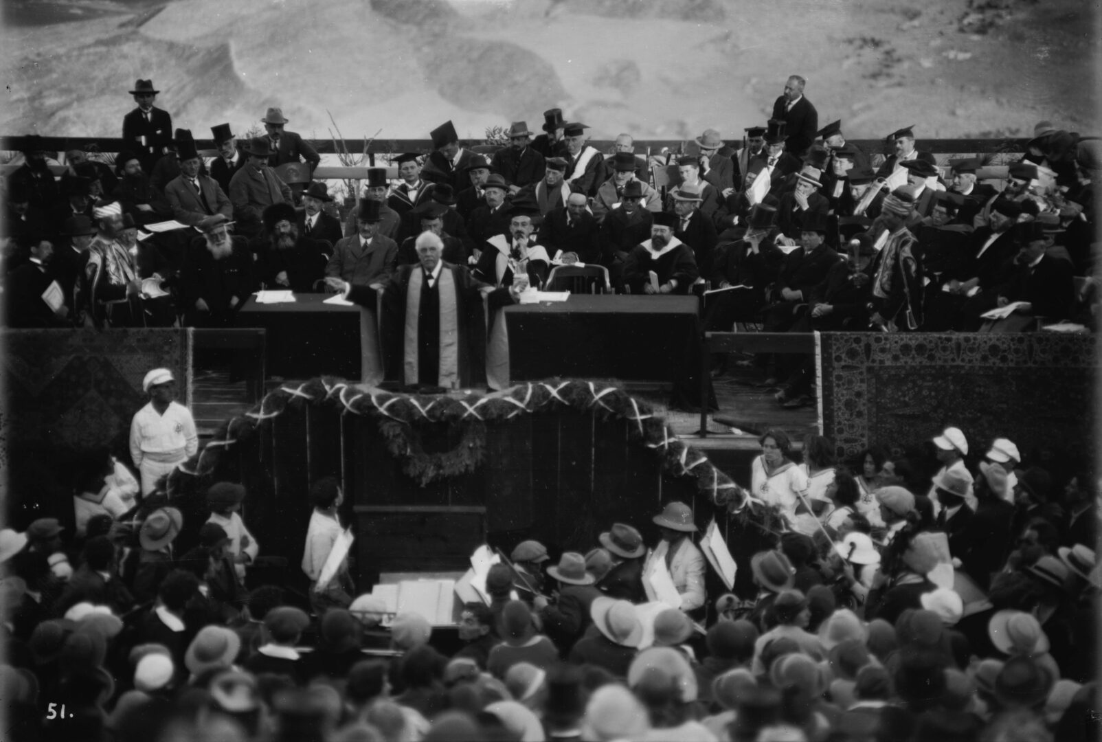 A black and white image of Balfour addressing a large crowd gathered at Mount Scopus for the dedication of the Hebrew University. 