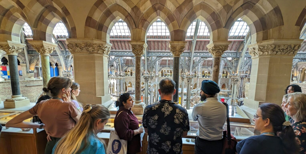 Unnatural-Histories-Tour People looking over artefacts in an Oxford Museum
